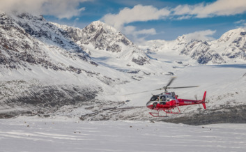 Helicopter takes off from Yanert Glacier surrounded by pristine mountains.