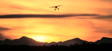 Floatplane flying over the sunset.