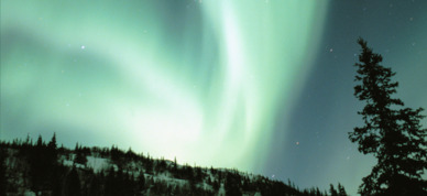 Northern lights over Alaskan cabin.