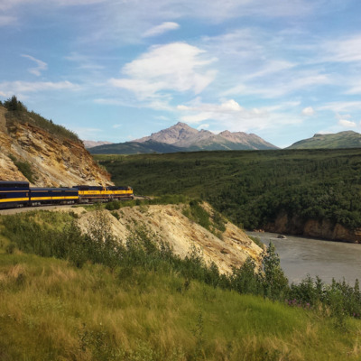 Alaska Railroad curves around a bend and follows the gray silty river on the way to Fairbanks.