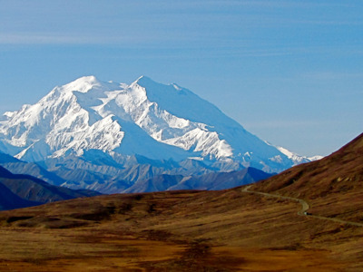 Bus heads up the Park Road under the shadow of Denali.