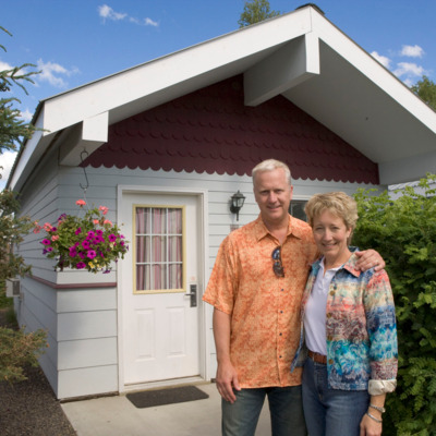 Couple standing outside of their River's Edge cottage.