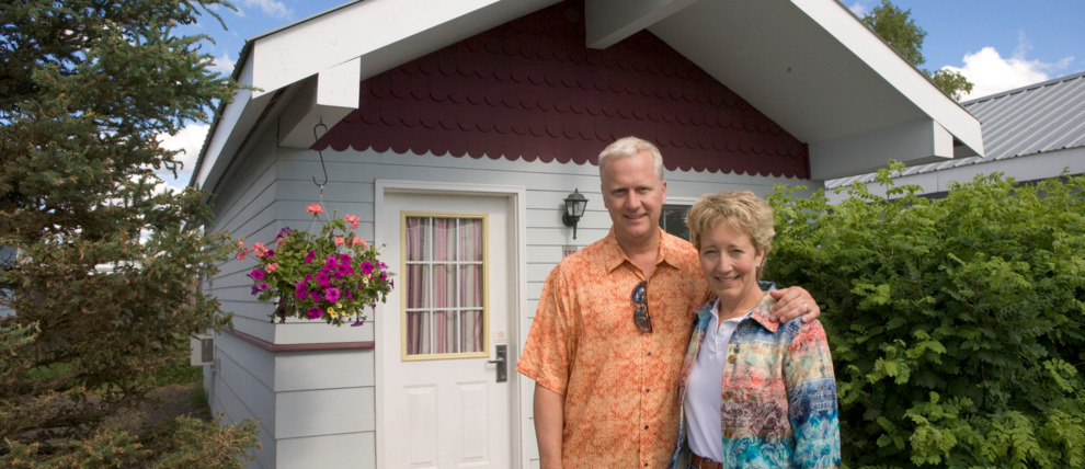 Couple standing outside of their River's Edge cottage. Couple standing outside of their River's Edge cottage.