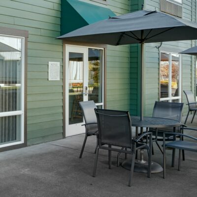 Communal patio with outdoor seating and a grill.