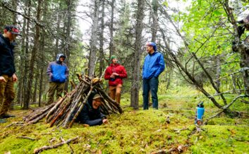 Learning shelter building skills on a survivalist hike.