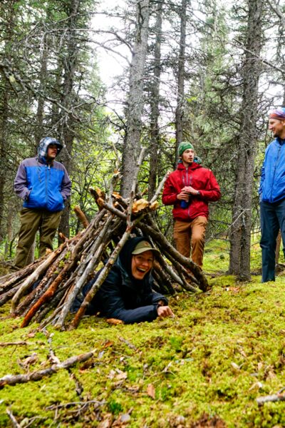 Learning shelter building skills on a survivalist hike.