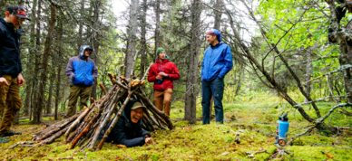 Learning shelter building skills on a survivalist hike.
